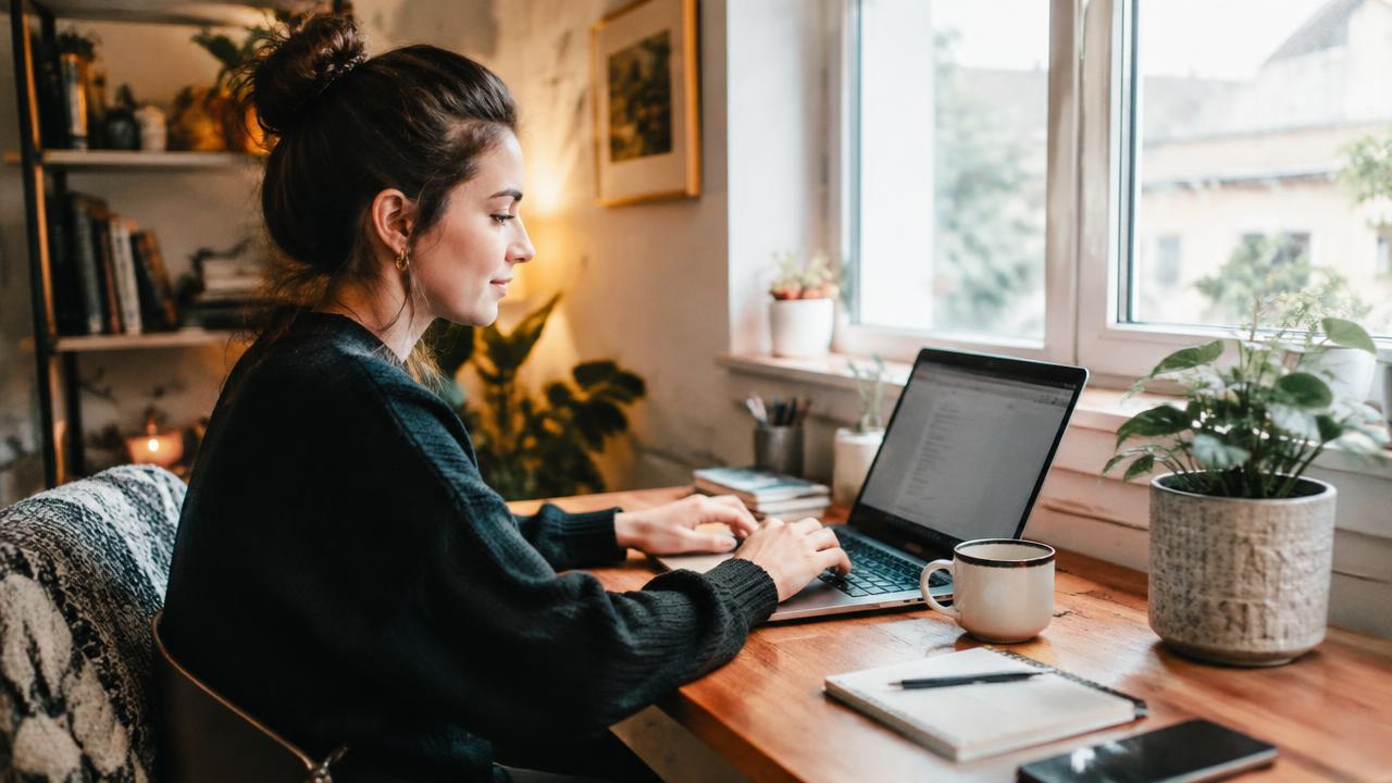 Profissional em home office iniciando a jornada pelo computador em mesa de trabalho em casa